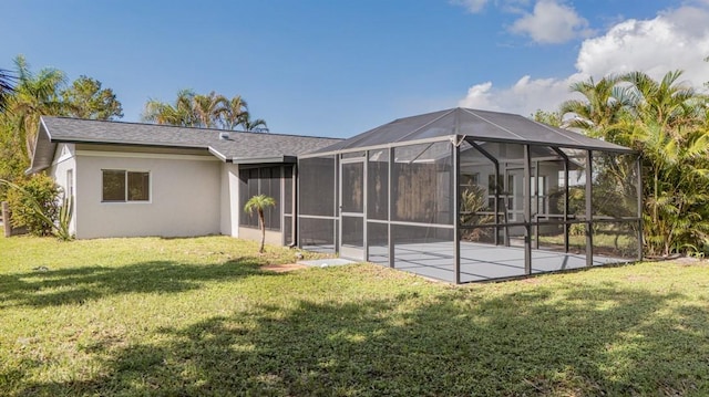 rear view of property with a lanai, a yard, and a patio area