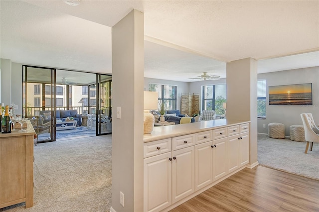 8779 Midnight Pass Rd Unit 206H, Sarasota, FL 34242 - kitchen featuring open floor plan, light colored carpet, white cabinetry, light countertops, and light wood finished floors