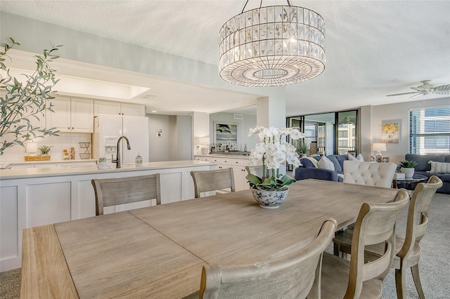 8779 Midnight Pass Rd Unit 206H, Sarasota, FL 34242 - dining space featuring light carpet, a textured ceiling, a chandelier, and ceiling fan