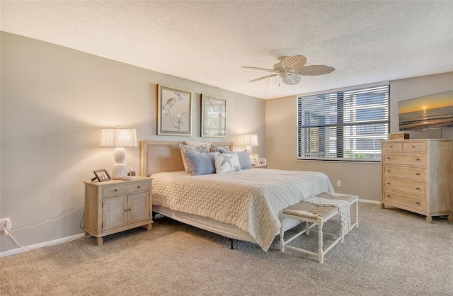 carpeted bedroom featuring a textured ceiling and ceiling fan