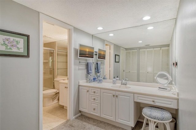 bathroom featuring tile patterned floors, vanity, an enclosed shower, and a textured ceiling