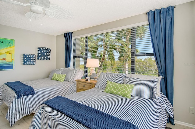 8779 Midnight Pass Rd Unit 206H, Sarasota, FL 34242 - bedroom with wood finished floors, a textured ceiling, baseboards, and ceiling fan