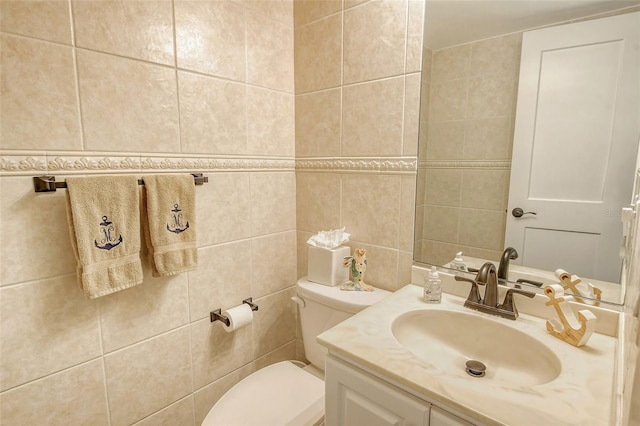 bathroom with vanity, tile walls, and toilet