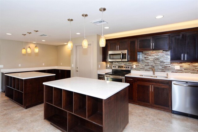 kitchen with decorative light fixtures, a center island, stainless steel appliances, and sink