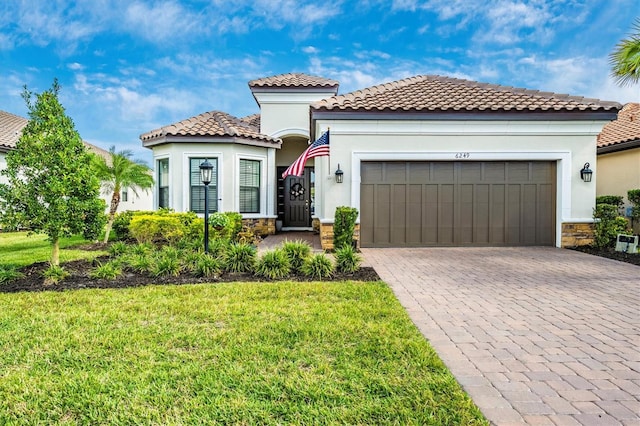 mediterranean / spanish house with a garage and a front lawn