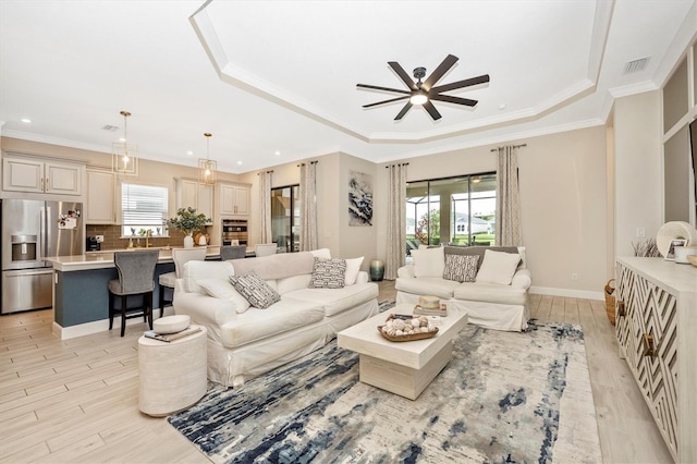 living room featuring ornamental molding, light hardwood / wood-style floors, a healthy amount of sunlight, and ceiling fan