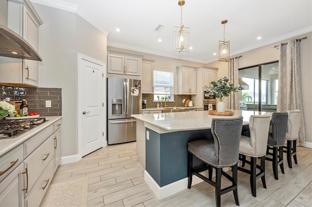 kitchen with stainless steel appliances, tasteful backsplash, wall chimney exhaust hood, decorative light fixtures, and a center island