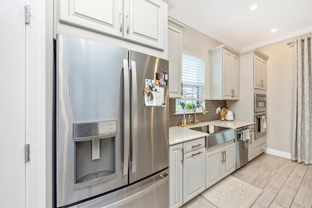 6249 Mesa Gln, Bradenton, FL 34203 - kitchen with appliances with stainless steel finishes, a sink, light countertops, tasteful backsplash, and crown molding