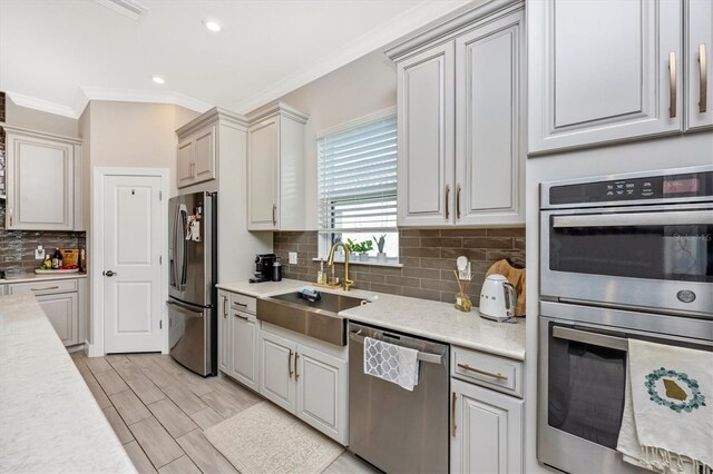 6249 Mesa Gln, Bradenton, FL 34203 - kitchen featuring appliances with stainless steel finishes, a sink, ornamental molding, tasteful backsplash, and recessed lighting