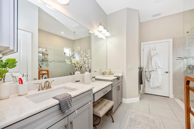 bathroom with vanity, tile patterned flooring, and a tile shower