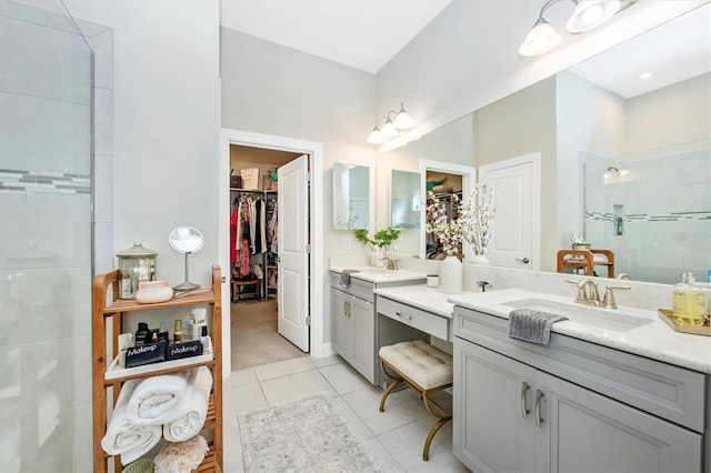 bathroom featuring a tile shower, vanity, and tile patterned floors