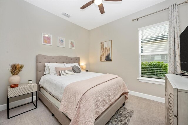 bedroom featuring light colored carpet and ceiling fan