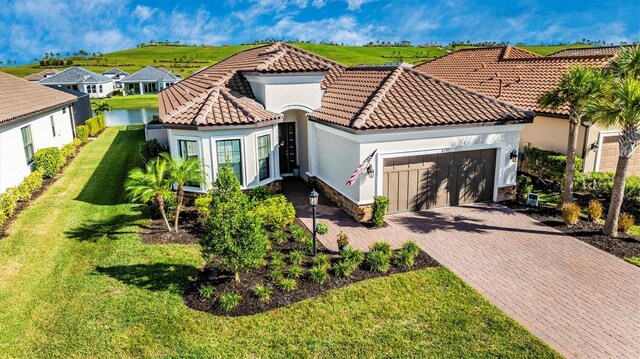 6249 Mesa Gln, Bradenton, FL 34203 - mediterranean / spanish-style house with a garage, stucco siding, decorative driveway, a tiled roof, and a front yard