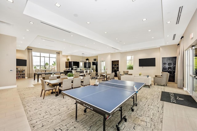 recreation room with a raised ceiling