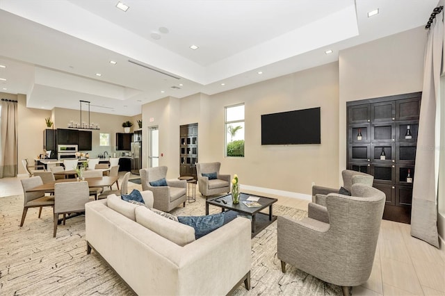 living room with a high ceiling and a tray ceiling