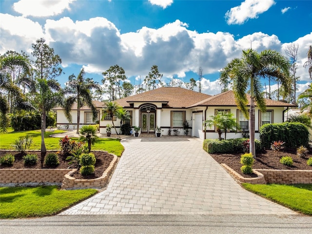 view of front of house featuring french doors, a front yard, and a garage