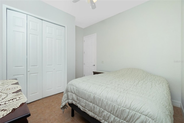 bedroom with tile patterned flooring, ceiling fan, and a closet