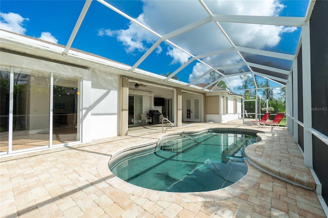 view of swimming pool featuring a patio and glass enclosure