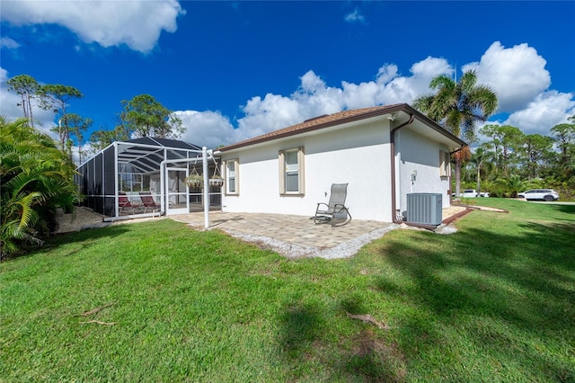 back of property with a lanai, a patio area, central air condition unit, and a lawn