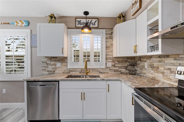 kitchen with white cabinetry, stainless steel appliances, sink, and light stone counters