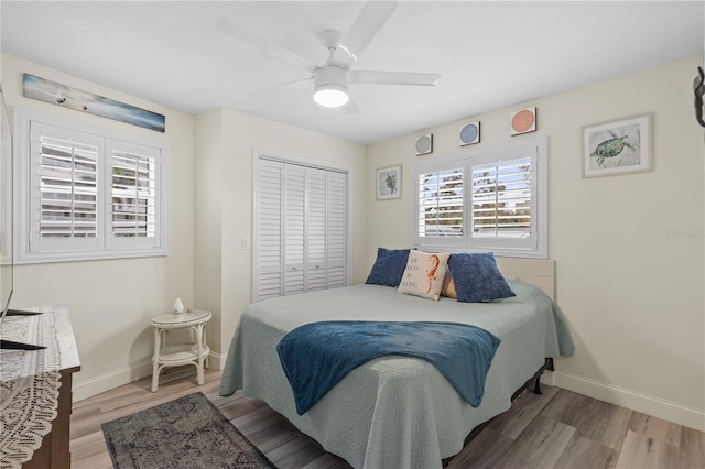 bedroom with a closet, hardwood / wood-style floors, and ceiling fan