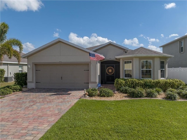 view of front of house with a front lawn, central air condition unit, and a garage