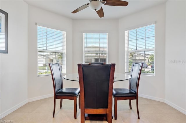 dining space with a healthy amount of sunlight, ceiling fan, and light tile patterned floors