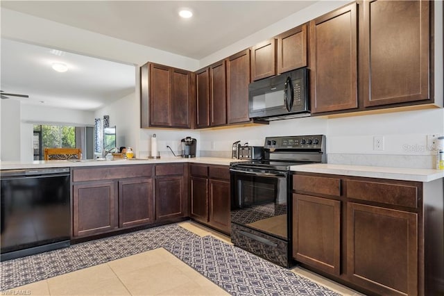 kitchen with dark brown cabinetry, sink, black appliances, kitchen peninsula, and light tile patterned floors