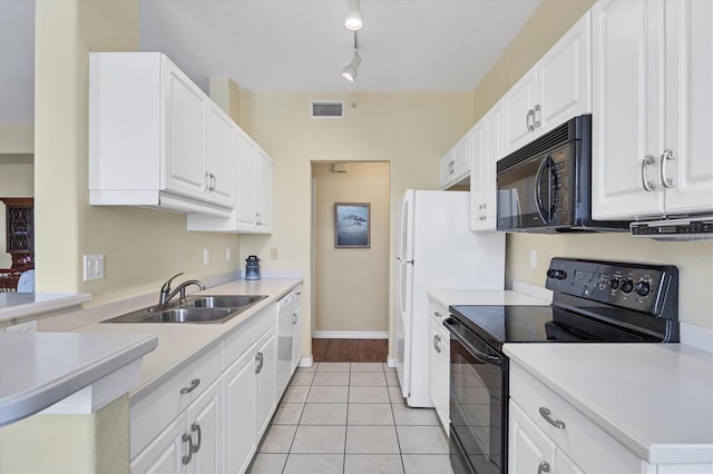 kitchen featuring sink, white cabinets, light tile patterned flooring, track lighting, and black appliances