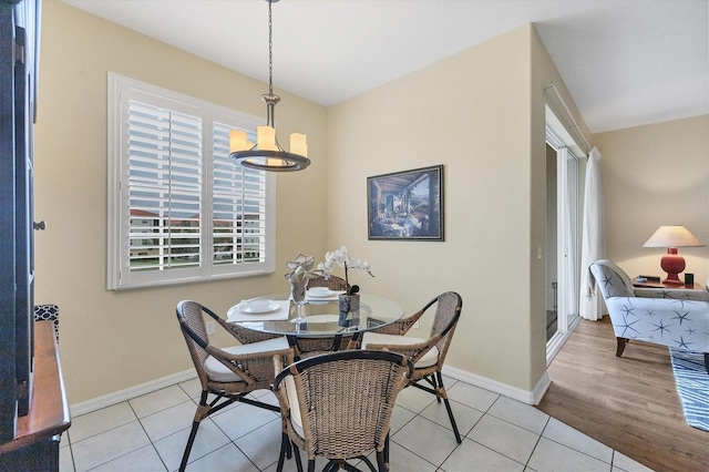 tiled dining space featuring a notable chandelier