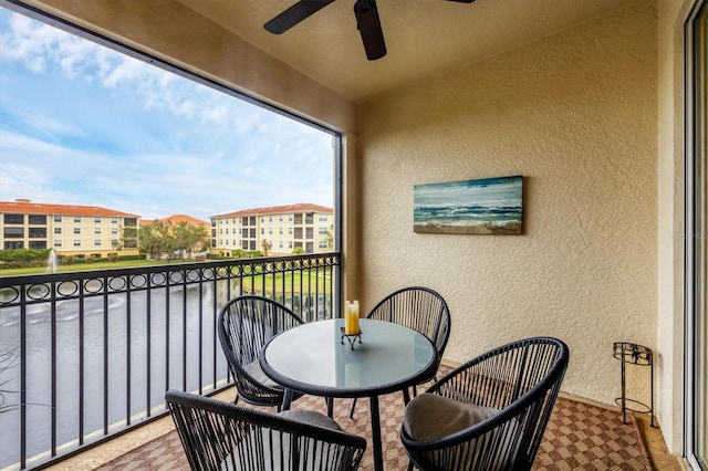 balcony featuring ceiling fan and a water view