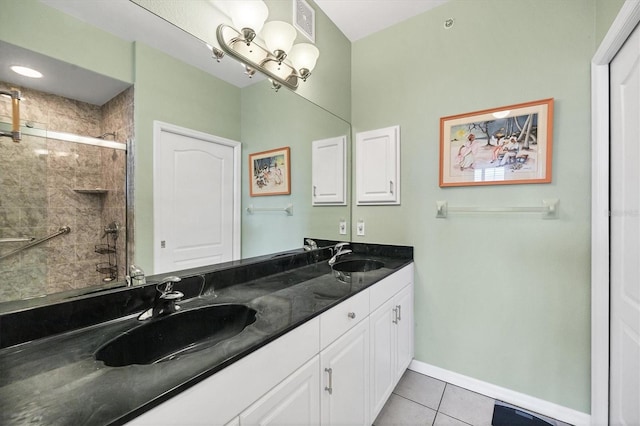 bathroom featuring tile patterned flooring, a shower with door, and vanity