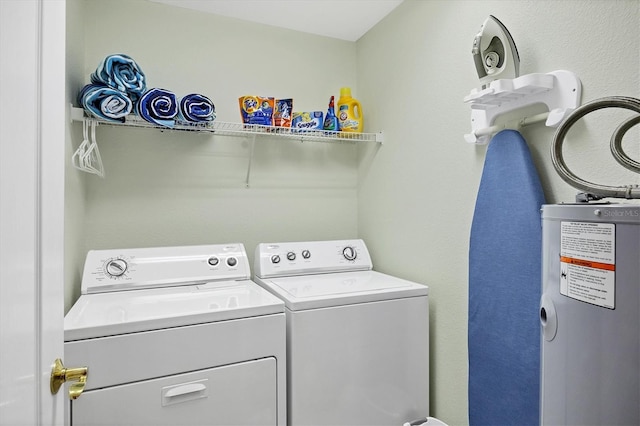 laundry area with water heater and washer and dryer