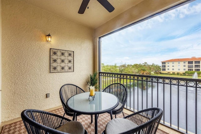 balcony with ceiling fan and a water view