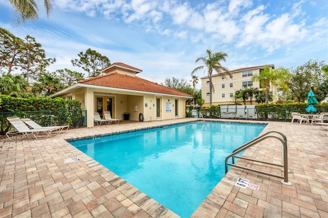 view of swimming pool with a patio and french doors