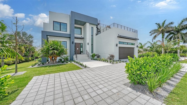 view of front of house with a balcony, a garage, and a front lawn