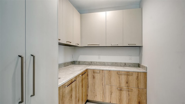 kitchen with white cabinets and light stone counters