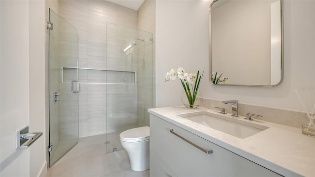 bathroom with tile patterned floors, vanity, toilet, and walk in shower