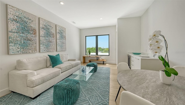 living room with wine cooler and light hardwood / wood-style flooring