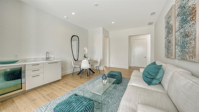 living room with light hardwood / wood-style flooring and sink