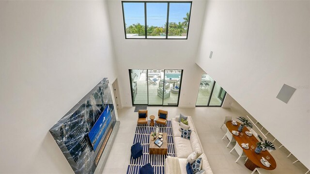 living room featuring a towering ceiling and light tile patterned floors