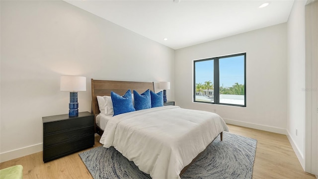 bedroom featuring lofted ceiling and light hardwood / wood-style flooring