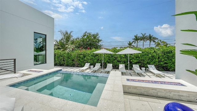 view of swimming pool with a patio, a fire pit, and a hot tub