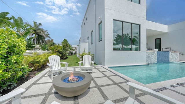 view of swimming pool featuring a patio and an outdoor fire pit