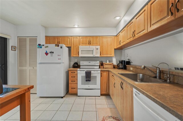 kitchen featuring white appliances, sink, and light tile patterned floors