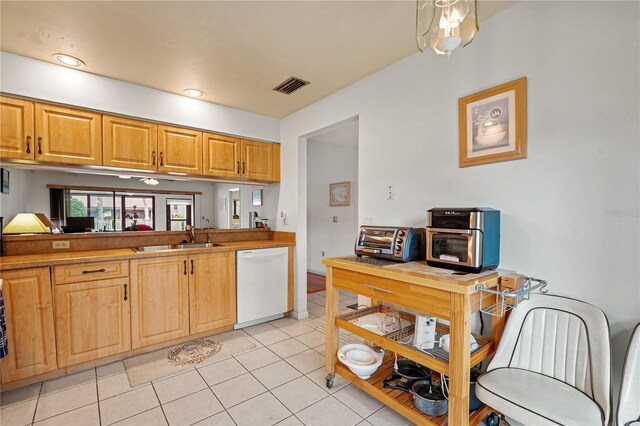 kitchen with dishwasher, light tile patterned floors, and sink