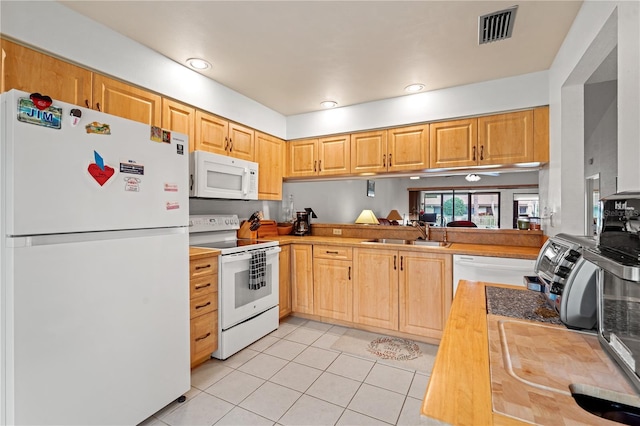 kitchen featuring sink, light tile patterned floors, white appliances, and light brown cabinets