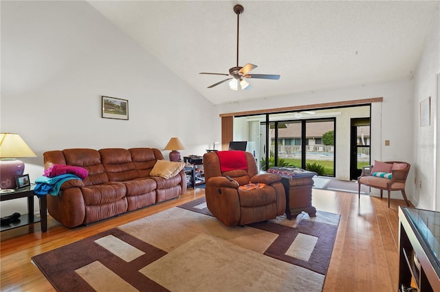 living room with ceiling fan, light hardwood / wood-style flooring, and high vaulted ceiling