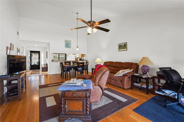 living room featuring hardwood / wood-style flooring, high vaulted ceiling, and ceiling fan