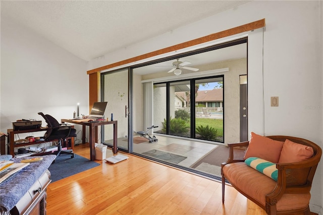 doorway featuring hardwood / wood-style floors, ceiling fan, and lofted ceiling